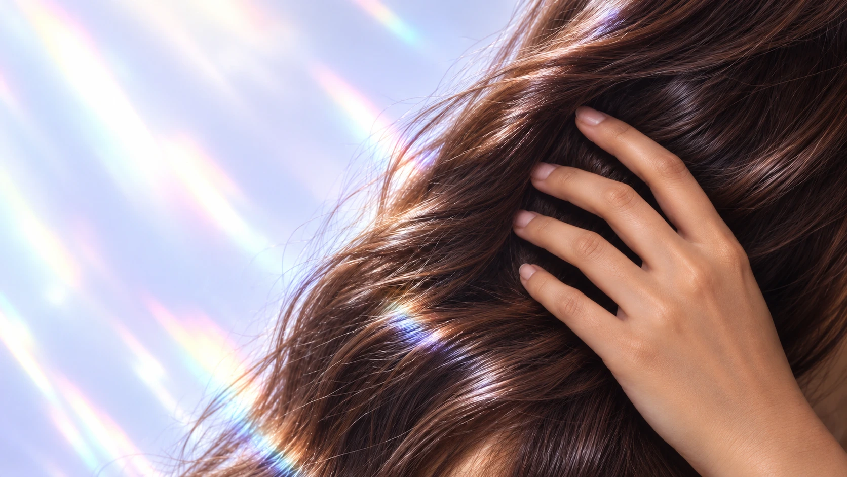 A gentle hand passing through glossy brunette hair